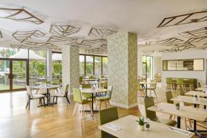 a restaurant with tables and chairs and windows at DoubleTree by Hilton London - Hyde Park in London