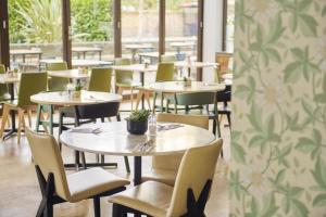 a row of tables and chairs in a restaurant at DoubleTree by Hilton London - Hyde Park in London