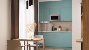 a kitchen with blue cabinets and a table at Harabruck Apartments in Gmünd