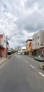 an empty street in a town with buildings at Quarto individual Aconchego in Divinópolis