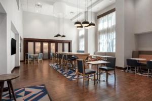 a dining room with tables and chairs and windows at Hampton Inn & Suites Harvey New Orleans Westbank in Harvey