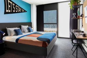 a bedroom with a king sized bed with a blue wall at The Social Hub Madrid in Madrid