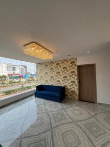 a blue couch in a room with a large window at ishika grand in Secunderabad