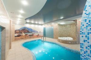 a large swimming pool in a bathroom with a bath tub at Gorky Hotel in Nizhny Novgorod