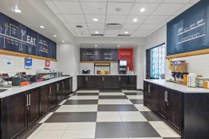 a kitchen with wooden cabinets and a checkered floor at Hampton Inn by Hilton Winnipeg in Winnipeg