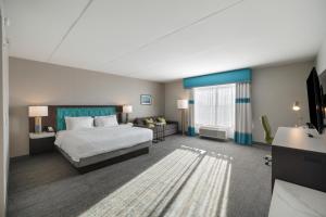 a large hotel room with a bed and a couch at Hampton Inn by Hilton Winnipeg in Winnipeg +24 photos