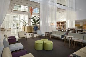 a lobby with chairs and tables and a restaurant at Hilton Barcelona in Barcelona