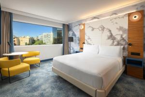 a hotel room with a bed and a large window at Hilton Barcelona in Barcelona +105 photos