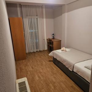 a small bedroom with a bed and a wooden floor at Pansion San Pietro in Međugorje