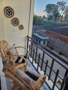 a balcony with a chair and a wreath on a wall at Azure View Studio with pool in Kiahuria