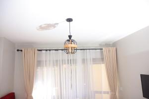 a chandelier hanging from a ceiling with a window at Azure View Studio with pool in Kiahuria