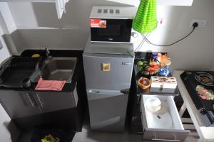 a small kitchen with a sink and a refrigerator at Azure View Studio with pool in Kiahuria
