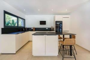 a kitchen with white cabinets and a black counter top at Enjoy 5Bdr villa pool and BBQ in Saint-Raphaël