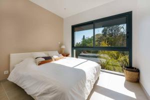 a bedroom with a white bed and a large window at Enjoy 5Bdr villa pool and BBQ in Saint-Raphaël +13 photos