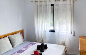 a bedroom with a bed with white curtains and a window at 2 Bedroom Lovely Apartment In Estepona in Estepona