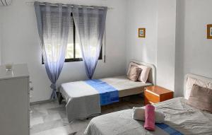 a bedroom with two beds and a window at 2 Bedroom Lovely Apartment In Estepona in Estepona +11 photos