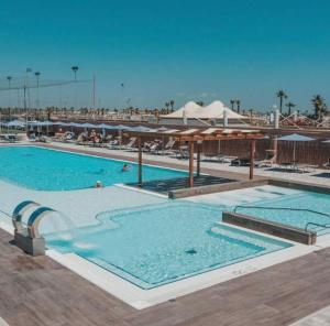 a large swimming pool with blue water in a resort at Maison Belle Vue in Chioggia