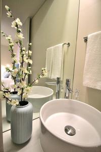 a bathroom with a sink and a vase with flowers in it at RestOnDouro Oporto Studio in Valbom