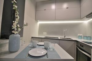 a kitchen with a table with plates and a vase with flowers at RestOnDouro Oporto Studio in Valbom +27 photos