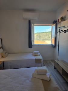 a bedroom with a bed and a window at Sol da Praia in Odeceixe