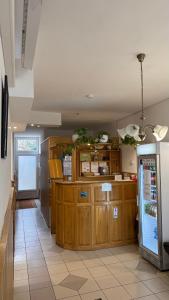 a kitchen with wooden cabinets and a refrigerator at Rózsakert Panzió in Nyíregyháza +9 photos