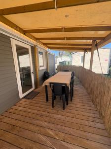 a patio with a table and chairs on a deck at Nadege in Lège-Cap-Ferret