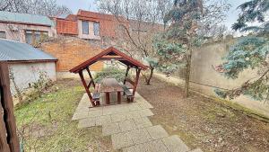 a small gazebo with a bench in a yard at Rózsakert Panzió in Nyíregyháza