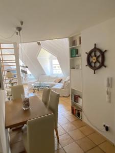 a dining room and living room with a table and chairs at Seeloge mit Dachterrasse direkt am Westhafen in Hagnau am Bodensee in Hagnau