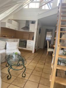 a living room with a glass table and a kitchen at Seeloge mit Dachterrasse direkt am Westhafen in Hagnau am Bodensee in Hagnau