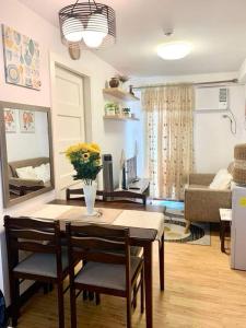 a living room with a table and chairs and a couch at Super Cozy Condo Davao in Davao City
