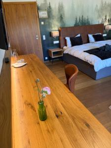 a wooden table with a vase with a flower on it at Landhaus Langeck in Münstertal