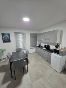 a kitchen with a table and a dining room at Center- Podčetrtek in Podčetrtek