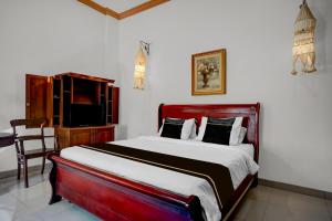 a bedroom with a bed and a desk and a television at Collection O near University of Sumatera Utara formerly Huber Apartment in Medan +28 photos