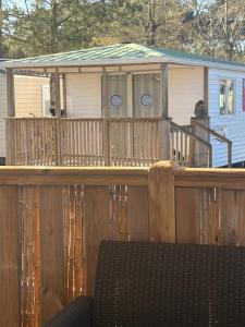 a wooden deck with a house with a green roof at Nadege in Lège-Cap-Ferret