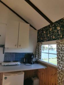 a kitchen with a counter and a window in a room at Stuga1-6 Dalskärs camping Badrum i Servicehus in Bergkvara