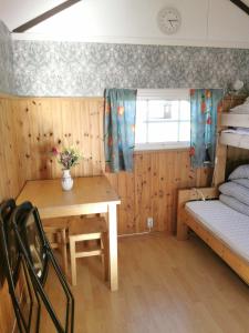 a room with a table and a bed and a desk at Stuga1-6 Dalskärs camping Badrum i Servicehus in Bergkvara