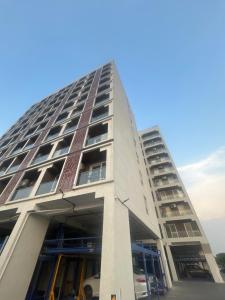 a tall building with a parking lot at Atelier Sol- ultra luxe aparthotel near airport in Pune