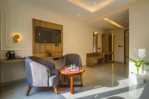 a living room with two chairs and a table at Tripli Hotels Solune in Rishīkesh