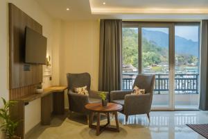 a room with two chairs and a table and a television at Tripli Hotels Solune in Rishīkesh