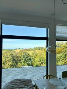 a room with a large window with a view of a deck at Summer House On Hillside Plot By Sejerø Bay in Fårevejle +18 photos