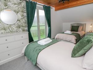 two beds in a bedroom with a window at Willow Lodge in Knighton