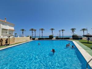 a group of people in the swimming pool at a resort at Seafront Chalet Muchavista direct beach access in El Campello