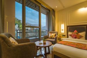 a hotel room with a bed and a large window at Tripli Hotels Solune in Rishīkesh +57 photos