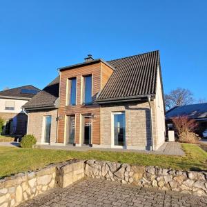 a house with a stone wall in front of it at Ferienhaus "Dorf-Glück" in Brilon