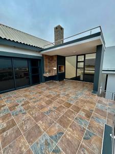 an outdoor patio with a fireplace in a house at EHH Accommodation Hentiesbay in Hentiesbaai