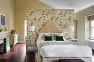 a bedroom with a large white bed with green pillows at Dripsey Castle Estate in Dripsey