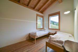 a room with two beds and a window at Chesa Pino - Madulain in Madulain