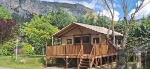 a cabin in the woods with a mountain in the background at Camping Manaysse in Moustiers-Sainte-Marie