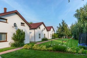 a house with a yard with a playground at Domki wczasowe AlexJan in Dąbki