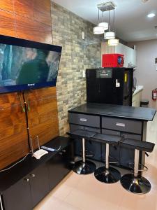 a kitchen with a desk and a tv on a wall at R and RMI CONDOTEL in Baguio